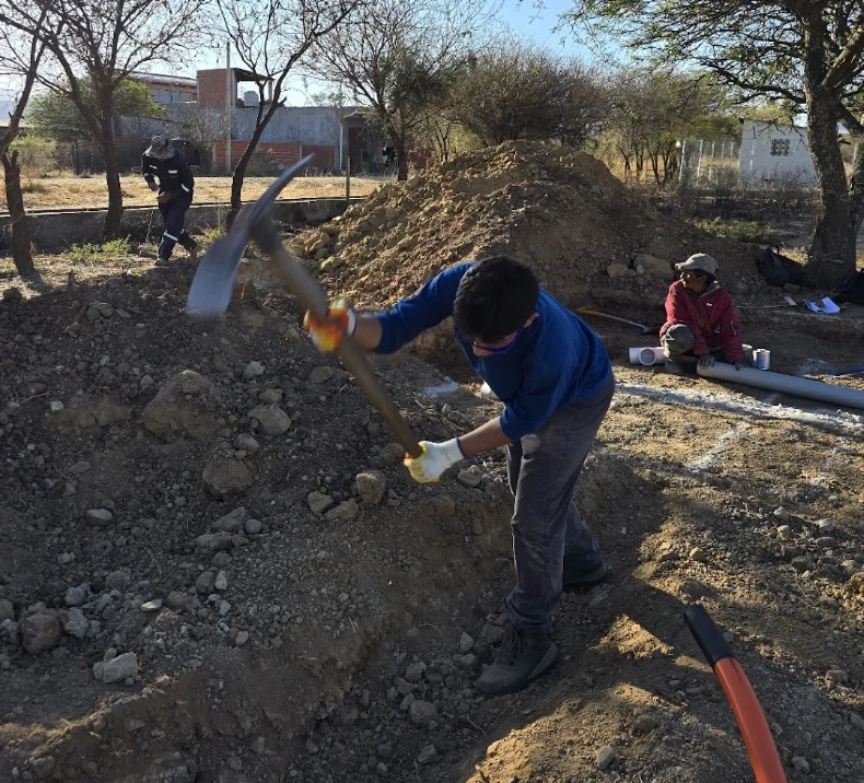 A community member breaking ground with a pickaxe