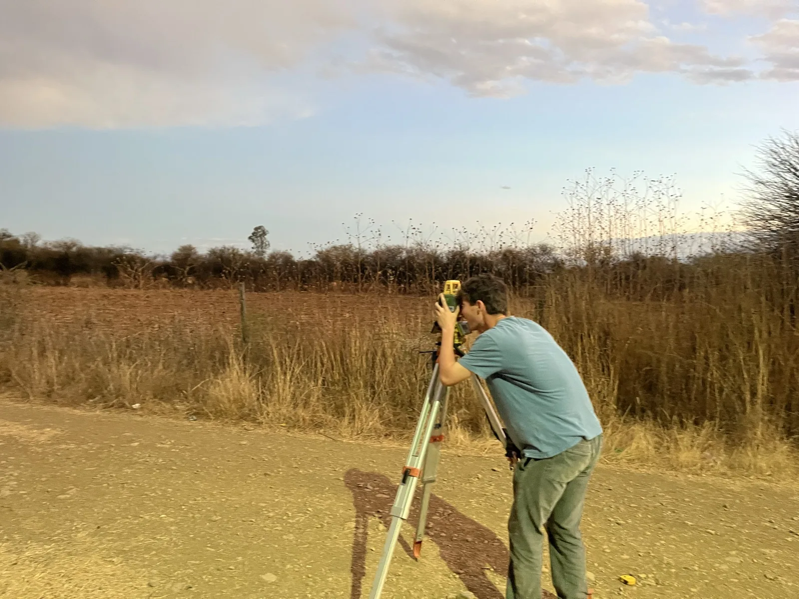 A team member collecting elevation data with a total station