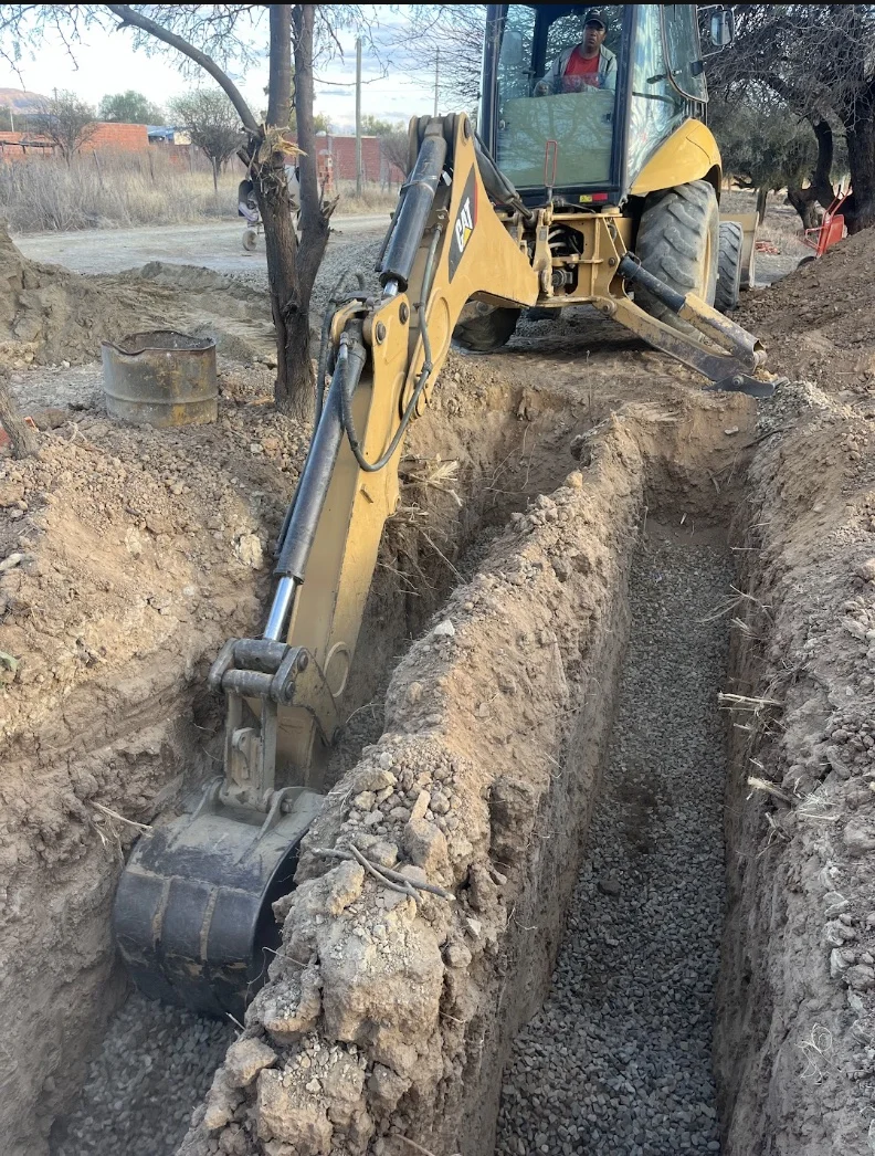 A backhoe excavating trenches for the leach field