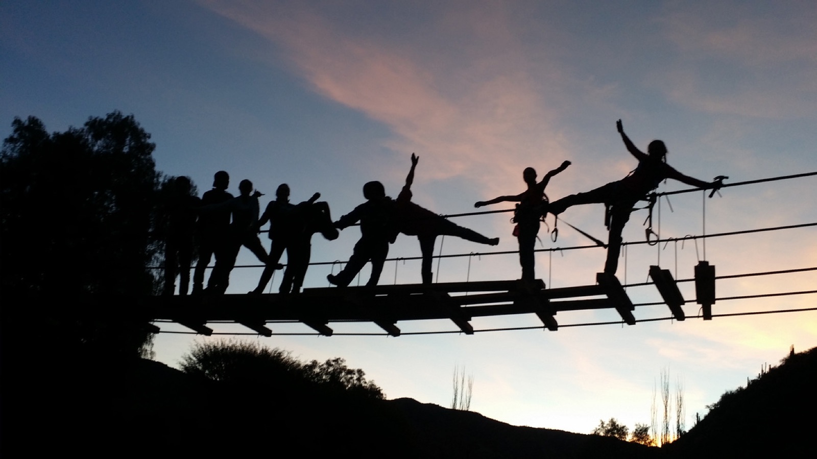 EWB Cornell members on a footbridge at sunset